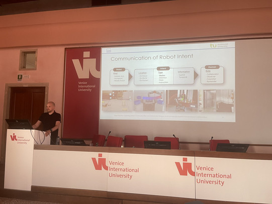 Max Pascher presents his work "Exploring Intent Communication and Interaction Designs for AI-enhanced Assistive Human-Robot Collaboration" at Fall IDC 2023 in Venice, Italy