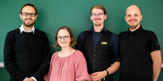 A picture showing the founding members of Team ihri in front of a green wall: Prof. Dr. Jens Gerken, Astrid Slojewski, Kirill Kronhardt, and Max Pascher (from left to right)
